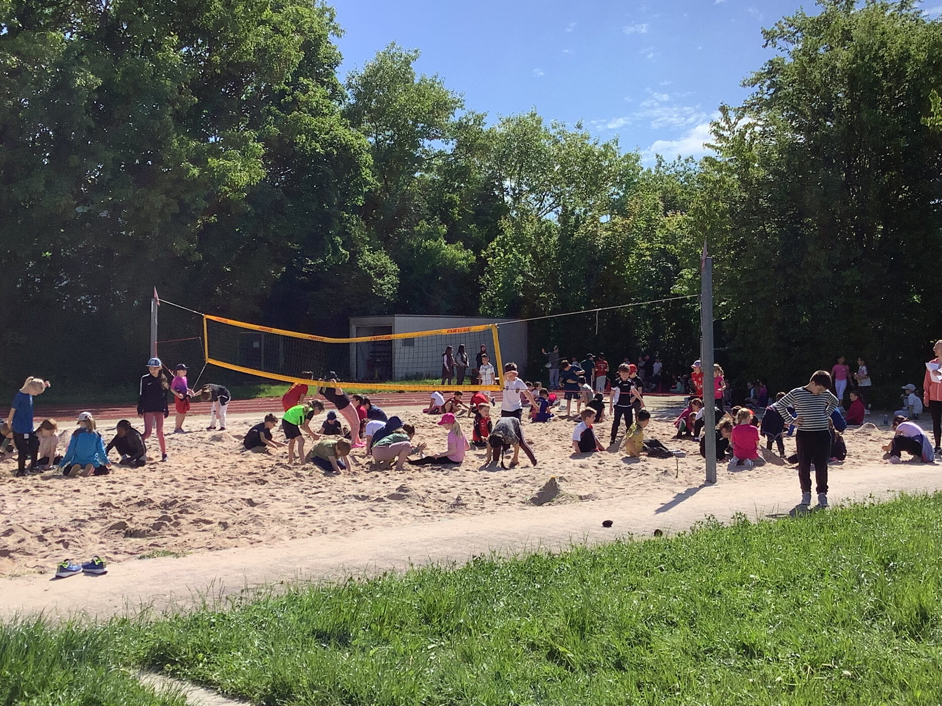 Viele Kinder spielen im Sand